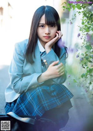 A young woman holding a strawberry in her hand.