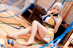 A woman in a yellow and white outfit sitting on the floor.