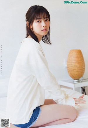 A woman in a white shirt is posing for a picture.