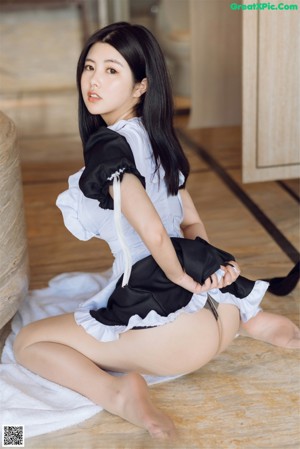 A woman in a maid outfit sitting on a bathtub.