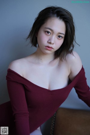 A woman in a red bodysuit posing for a picture.