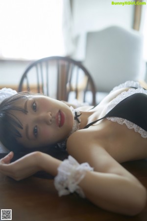 A woman in a maid outfit posing for a picture.