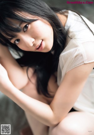 A woman with long black hair and a white shirt.