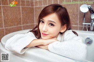 A woman sitting in a bathtub wearing black stockings.