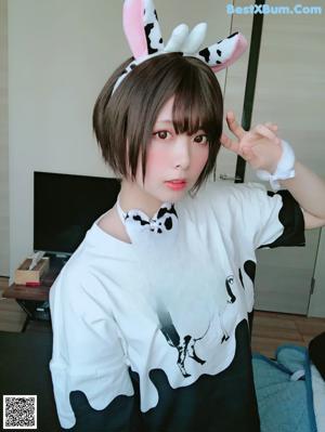 A woman wearing a white shirt with a cow print on it.