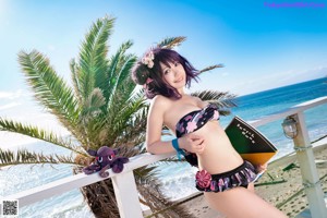 A woman laying on a beach next to an umbrella.