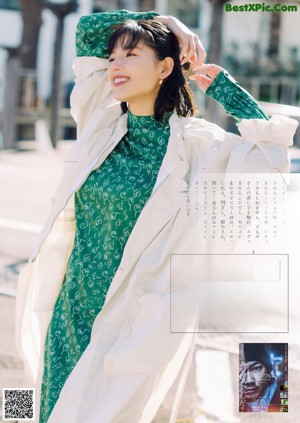 A woman in an orange dress is posing for a magazine.