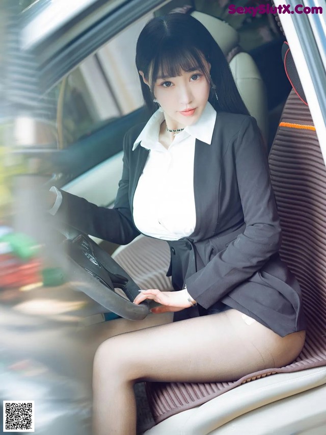 A woman sitting in the driver's seat of a car.